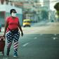 A woman wearing leggings depicting the US flag, walks along a street in Havana, on April 13, 2020