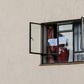 A man in mandatory quarantine in Kenya holds a sign reading "help me" out of the window of a facility in Nairobi