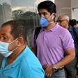 Two men wear protective face masks in Cali, Colombia, on March 12, 2020
