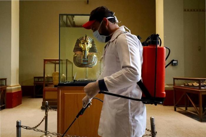 A cleaner disinfects the display case housing the gold funeral mask of famed pharaoh Tutankhamun at the Egyptian Museum in Cairo