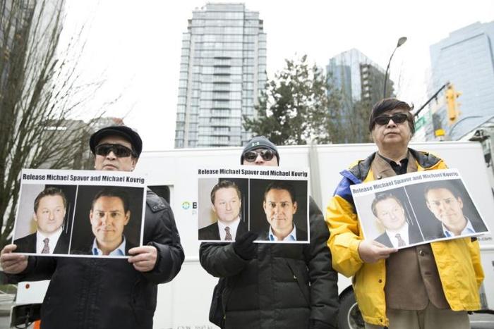 Protesters in Vancouver hold photos of Michael Spavor and Michael Kovrig. The pair have now been held in detention in China for more than 500 days