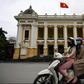 Women wearing face masks ride past the Opera House in Hanoi on April 23, 2020, as Vietnam eased its nationwide social isolation effort to prevent the spread of the COVID-19 novel coronavirus. Vietnam eased social distancing measures on April 23, with e...