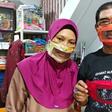 Imama Saroso and his wife Faizah Badaruddin, who are hearing and speech-impaired, pose with homemade face masks which enables people with disabilities to read lips