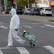 A woman wearing a hazmat suit and googles pulls her grocery cart through New York City on April 20, 2020