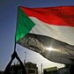 The Sudanese flag flies in Khartoum during a commemoration of a deadly raid a year ago on an anti-government sit-in