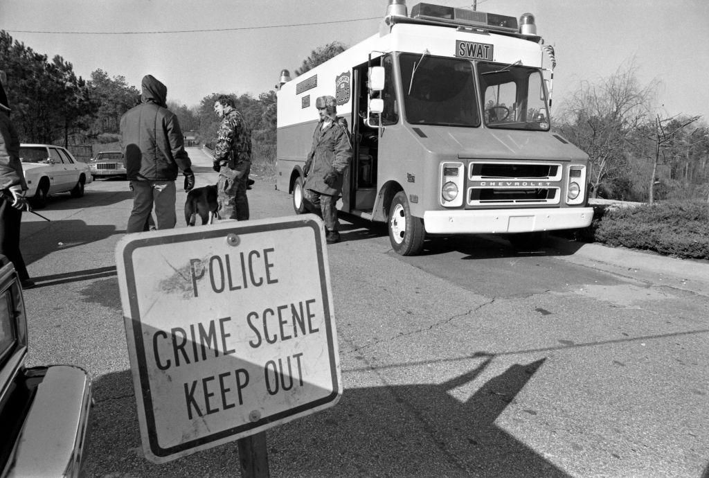 More than 200 Atlanta Police SWAT team and other police officers work with dogs to search through a trash-littered suburban woods where the skeletons of two children were discovered on January 9.