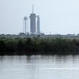 SpaceX's Falcon 9 rocket in the background as dolphins swim in a lagoon near Launch Pad 39A at the Kennedy Space Center in Florida