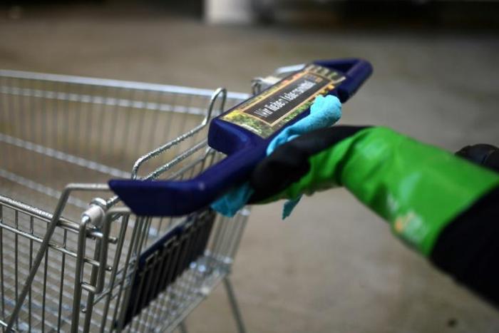 Katharina Obladen and Tanja Nickel have seen demand for their virus-killer products skyrocket -- here a student cleans a shopping trolley for disinfection at their workshop in Cologne