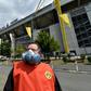 A Borussia Dortmund worker wears a mask outside the Signal Iduna Park stadium before the team face Schalke 04 as the Bundesliga resumes