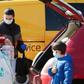 A family ensure they have their masks on as they put shopping in the car in Brunn am Gebirge near Vienna