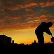 A worker wearing protective clothing digs a grave for a coronavirus victim at the Caju cemetery in Rio de Janeiro, Brazil on May 28, 2020