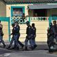 South African police patrol the street during clashes with residents (not visible) of Tafelsig, an impoverished suburb in Mitchells Plain, near Cape Town, on April 14, 2020, after some people in the community did not receive food parcels