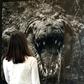 A woman observes the photograph titled "Large Crocodrillos" by Peter Beard at Sotheby's in 2008 for the Quillan Collection of Nineteenth and Twentieth Century Photographs