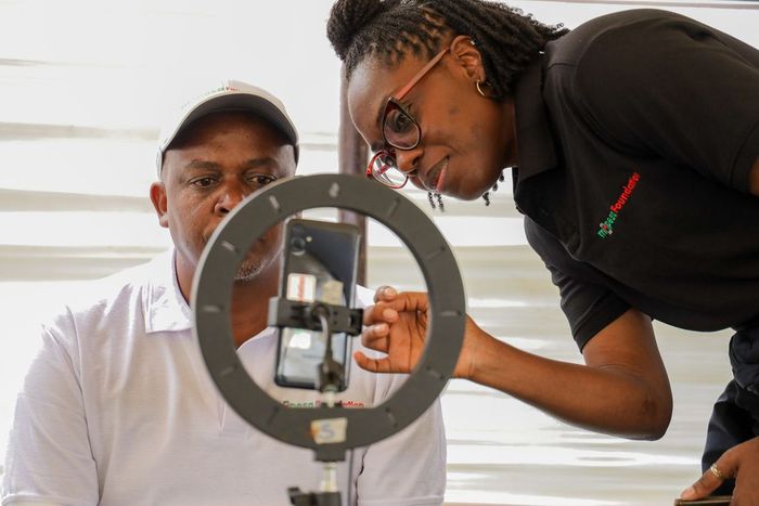 Kirubi Thairu, Rift Regional Business Lead, Safaricom PLC, undergoes AI Screening, assisted by Zuri Health member Uche, during a free medical camp held by M-PESA Foundation at Kapcheluch Primary School, Kericho County.