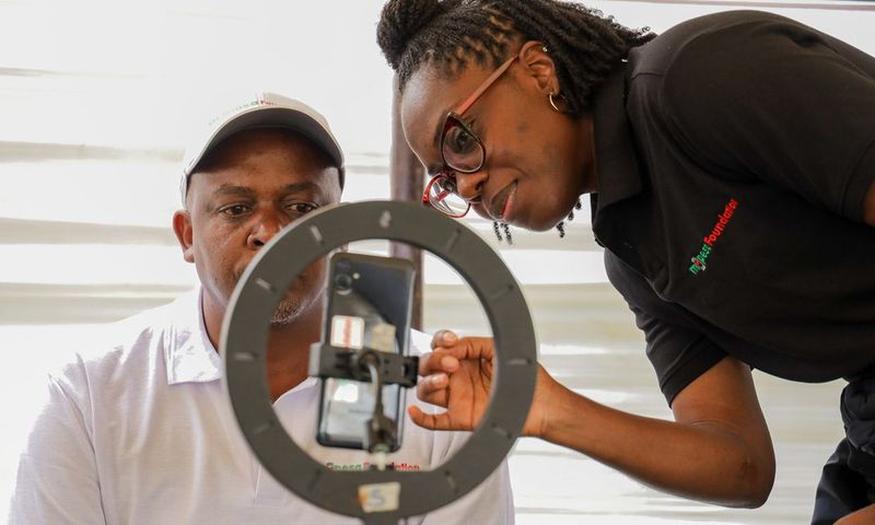 Kirubi Thairu, Rift Regional Business Lead, Safaricom PLC, undergoes AI Screening, assisted by Zuri Health member Uche, during a free medical camp held by M-PESA Foundation at Kapcheluch Primary School, Kericho County.