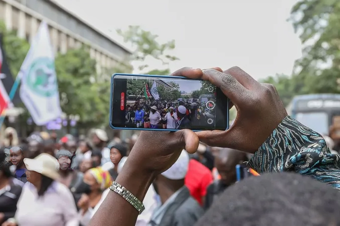 A photo of a person recording a video on their phone