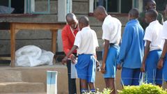 An invigilator frisking exam candidates