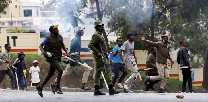 Armed goons pictured walking alongside the police in the streets of Nairobi during protests in Nairobi earlier in June