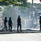 Police clear debris that was placed in the road by young demonstrators during protests against President Alassane Ouattara's run for a third term, in the Yopougon neighbourhood of Abidjan on August 13, 2020