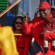 Irfaan Ali holds his son as he arrives at a campaign rally in Lusignan, Guyana on February 29, 2020