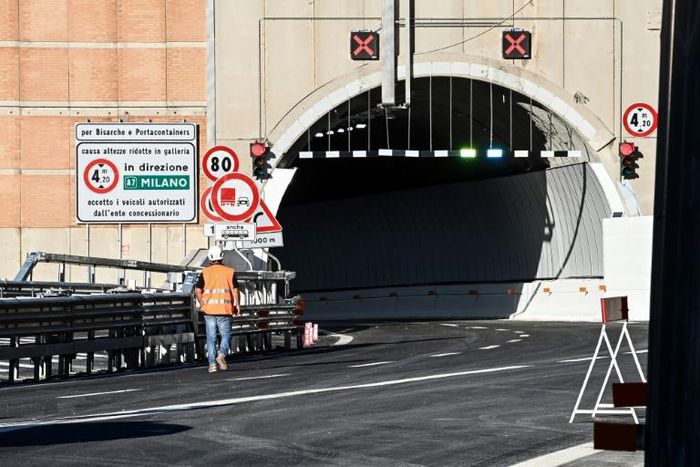 A worker walks near a tunnel before the opening of the new San Giorgio bridge for vehicles