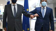 Cypriot Foreign Minister Nicos Christodoulides (R) greets with an elbow bump his Greek counterpart Nikos Dendias in Nicosia