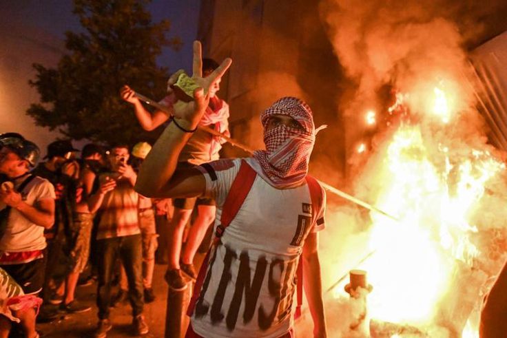 A Lebanese protester flashes the victory sign amid clashes with security forces in the centre of Beirut on Tuesday night