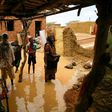 A Sudanese family inspects the damage to their home, after flash floods swept through the town of Umm Dawan Ban, southeast of the capital Khartoum, earlier this week