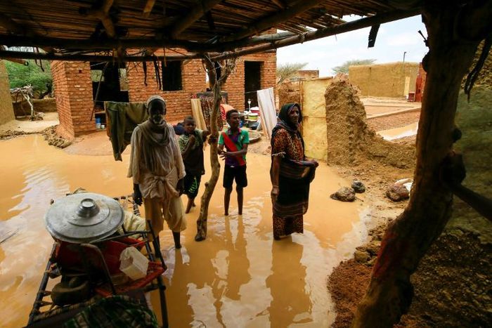 A Sudanese family inspects the damage to their home, after flash floods swept through the town of Umm Dawan Ban, southeast of the capital Khartoum, earlier this week