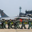Indian Air Force personnel march past one of the new Rafale jets at the Ambala base