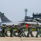 Indian Air Force personnel march past one of the new Rafale jets at the Ambala base