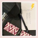 notepad with workout written down, resistance band, and dumbbell