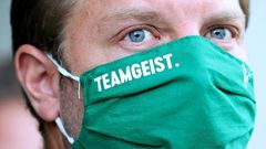 The Werder Bremen squad, under head coach Florian Kohfeldt seen here wearing a face mask bearing the logo "team spirit", has also agreed to another pay-cut