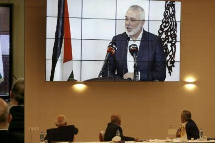 Palestinian factions gathered at their embassy in Beirut attend by video conference talks with president Mahmud Abbas (screen), while their counterparts in the West Bank watch speech of Hamas chief Ismail Haniyeh in Beirut