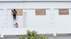 Workers board up the windows of a store in preparation for hurricane Nana in Belize City on Wednesday