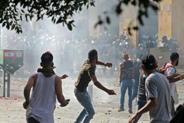 Lebanese protesters hurl rocks towards security forces during clashes in downtown Beirut