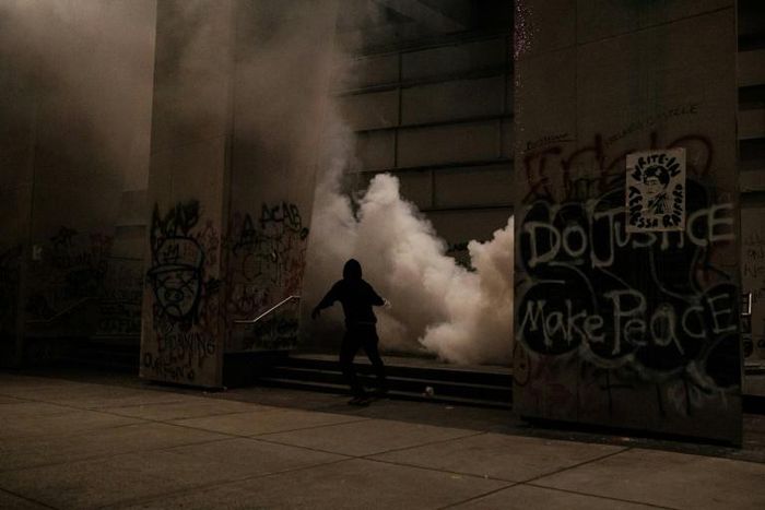 Protestors run after law enforcment fire tear gas
on the steps of the US District Court building in Portland, Oregon