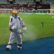 A worker disinfects the pitch at half time during the Rio de Janeiro state championship football final match between Flamengo and Fluminense at Maracana stadium, Rio de Janeiro, Brazil on July 15, 2020