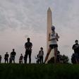 Members of  the Covid Memorial Project hold American flags in front of the Washington monument to commemorate the victims of the coronavirus