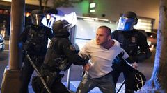Police detain a man who was with the victim of a shooting in Portland, Oregon on August 29, 2020