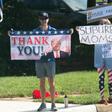 Supporters of Donald Trump and Joe Biden wave competing signs as the president's convoy arrives at a golf course in Sterling, Virginia, on August 23, 2020