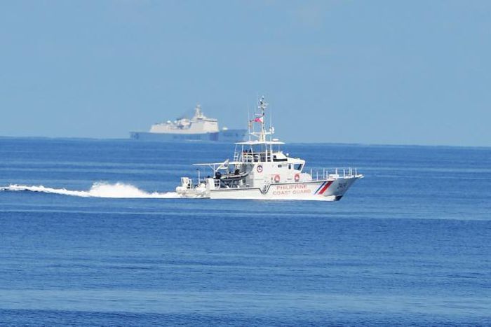 A Philippine coastguard ship BRP Langgam sails past a Chinese coastguard ship (background) near the Scarborough shoal in 2019