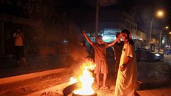 Libyan youth block a road with burning tyres in the eastern city of Benghazi to protest against poor public services and living conditions