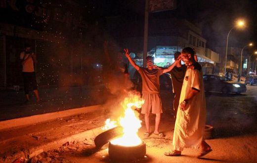 Libyan youth block a road with burning tyres in the eastern city of Benghazi to protest against poor public services and living conditions