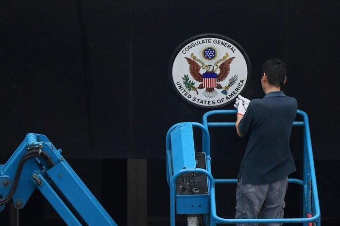 A worker removes the Great Seal of the United States from the front of the US consulate in the Chinese city of Chengdu