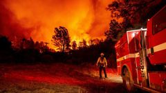 Butte County firefighters watch as flames tower over their truck at the Bear fire in Oroville, California