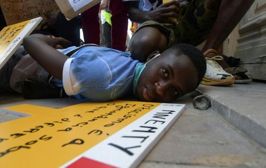 In this file photo from June 6, youths at an anti-racism solidarity rally in Tunisia re-enact the event leading to the death of George Floyd