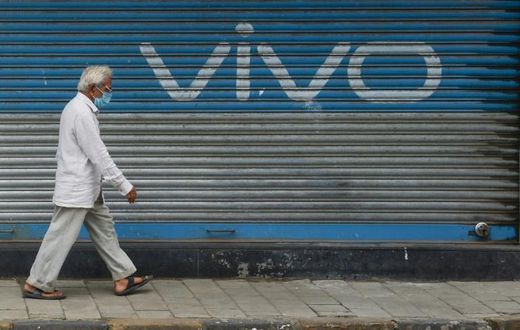 A pedestrian walks past an advert for Chinese mobile phone maker VIVO in Mumbai