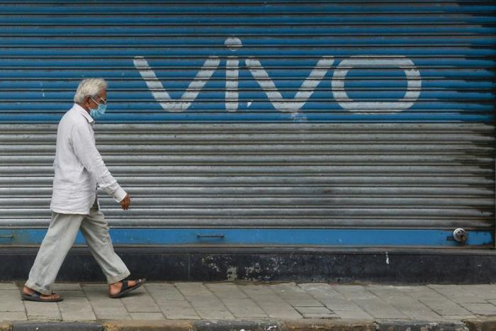 A pedestrian walks past an advert for Chinese mobile phone maker VIVO in Mumbai