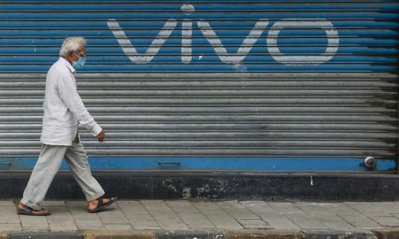 A pedestrian walks past an advert for Chinese mobile phone maker VIVO in Mumbai